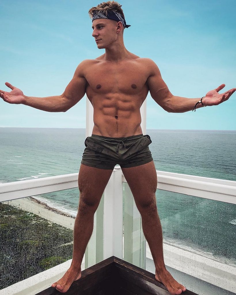 Max Wyatt posing on a balcony looking fit and lean.