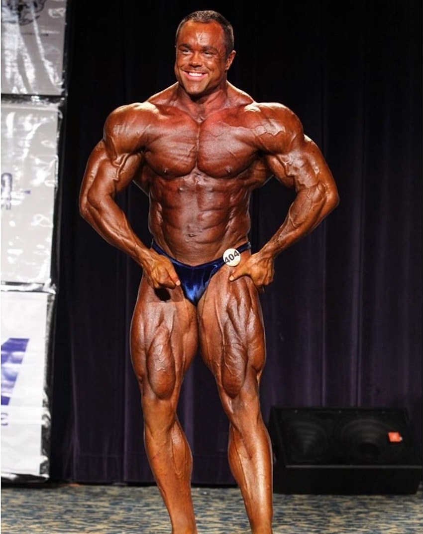 Ron Partlow flexing on the bodybuilding stage, looking ripped and huge